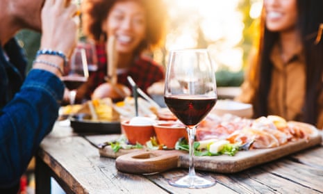 Happy family having barbecue party in backyard - Young friends celebrating at dinner drinking red wine at sunset - Focus on wine glass